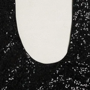 Nahaufnahme von glitzernden schwarzen Pailletten am Ausschnitt eines eleganten Abendkleids.