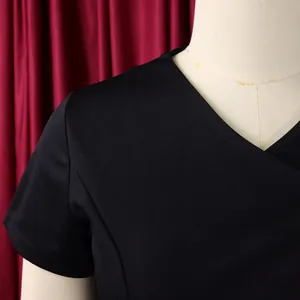 Close-up of black V-neck short sleeve top showing fabric texture and shoulder detail
