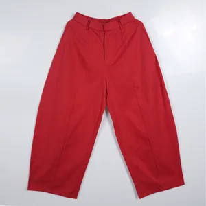 Detail view of vibrant red loose-fitting commuter trousers with high waist design