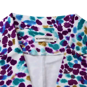 Primo piano del colletto di un blazer a motivi viola e blu con etichetta Metamorphosis Girl