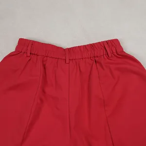 Detailed view of the elastic waistband and belt loops on red loose casual pants