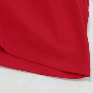 Nahaufnahme des roten Jumpsuits mit unregelmäßigem Saum und feinen Nähdetails.