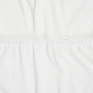 Close-up detail of the white pleated fabric texture for an elegant wide-leg two-piece set