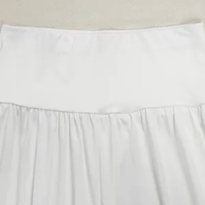 Close-up detail showing the waist texture of white pleated wide-leg trousers set
