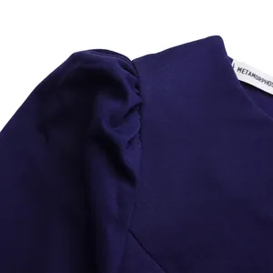 Close-up of a navy blue dress showing the puffed shoulder detail and fabric texture.