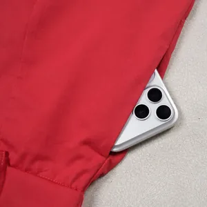Close-up detail of large side pocket on red casual trousers showing storage capacity
