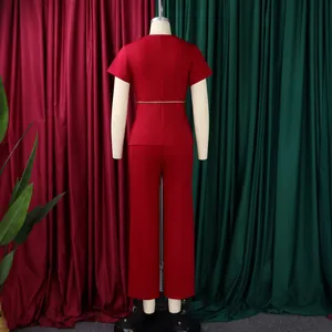 Back view of elegant red short-sleeve top and matching trousers set on a mannequin
