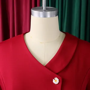 Detailed view of red V-neck top with daisy brooch from a two-piece casual suit set