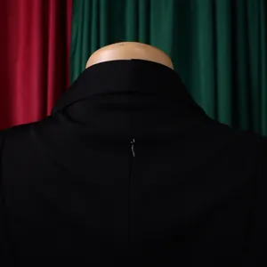 Dettaglio dello scollo posteriore e della cerniera invisibile su un abito nero con colletto