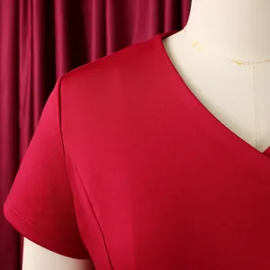Detail view of the elegant V-neckline and premium fabric texture on red short-sleeved top