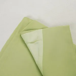 Détail montrant les coutures fines et la doublure intérieure de la combinaison ajustée vert clair
