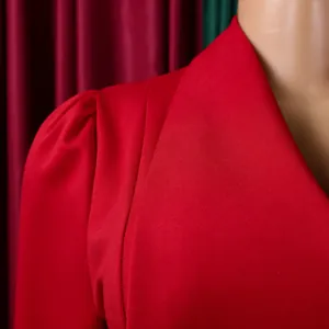 Primo piano dettagliato che mostra l'elegante bavero grande e la spalla a sbuffo di un abito rosso