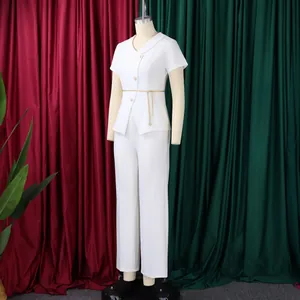 Detail view of a white two-piece set featuring short sleeve button top and trousers