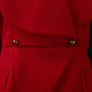 Macro della trama del tessuto twill rosso elegante e dei bottoni dorati su un abito
