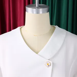 Detail view of a white V-neck blouse featuring a delicate daisy flower button closure