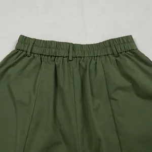 Detailed view of army green wide-leg trousers with elastic waistband and belt loops