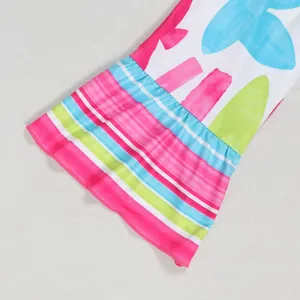 Detail of vibrant floral print dress showing flared ruffled sleeve with abstract patterns.
