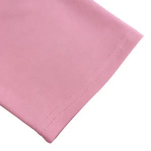 Close-up detail of the precise double-needle topstitching on a pink dress sleeve edge