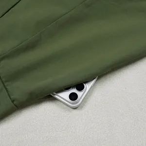 Detail view of deep side pocket on olive green loose commuting trousers