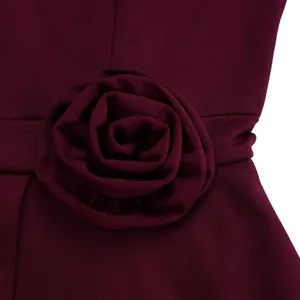 Makrodetail der eleganten 3D-Stoffblume an der Taille eines weinroten Cocktailkleides