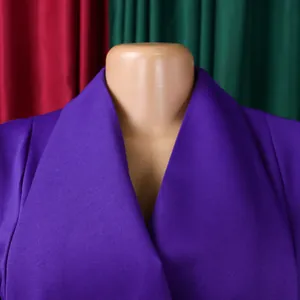Primo piano dell'elegante ampio rever su un vibrante abito viola da ufficio per donna.