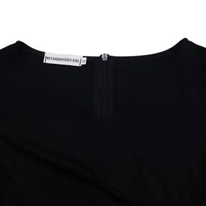 Detailed view of the elegant V-neckline and back zipper of a black pleated dress.