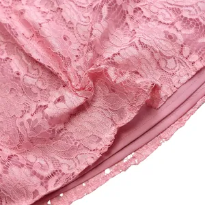 Macro detail shot of intricate floral pink lace fabric with matching inner lining.