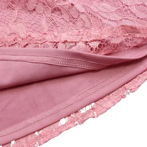 Macro view of pink lace dress hem showing high-quality stitching and fabric texture