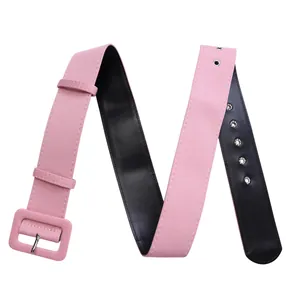 Detail of a pink fabric wide belt with a matching fabric-covered rectangular buckle.