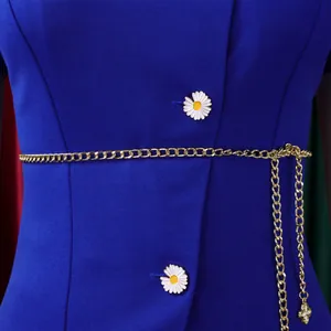 Detailed view of a blue stylish top featuring daisy buttons and a gold chain belt.