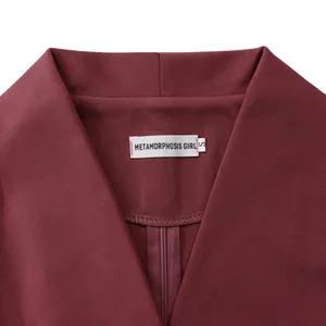 Dettaglio dello scollo a V e dell'etichetta su un elegante abito da ufficio bordeaux.