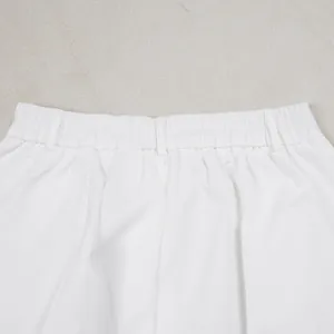 Detailed macro view of the elastic waistband and belt loops on white commuter casual pants