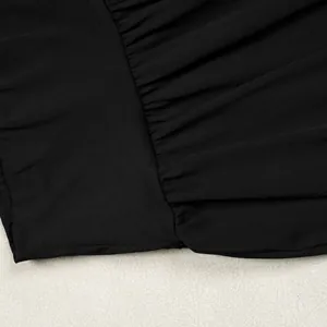 Close-up of pleated black fabric detail on an elegant wide-leg two-piece outfit set.