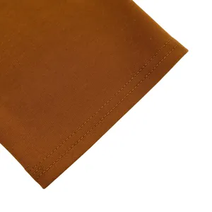 Nahaufnahme des braunen Strickstoffs mit feiner Textur und robusten Doppelnähten