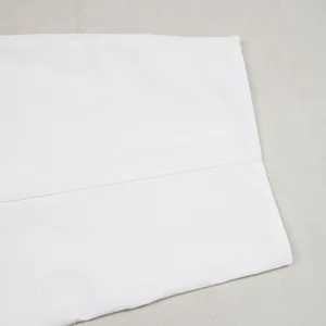 Macro view showing the precise stitching and fabric on white wide-leg casual trousers.