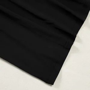 Detailed macro view of black pleated wide-leg trousers hem featuring double-needle stitching