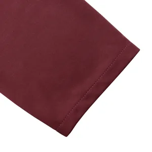 Dettaglio dell'orlo della manica del vestito bordeaux con cuciture fini di alta qualità.