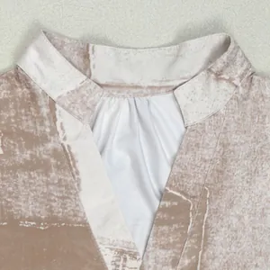 Close-up detail of V-neckline with pleated contrast insert on beige floral print dress