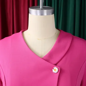 Close-up of a vibrant pink short-sleeved top featuring a cute daisy button detail