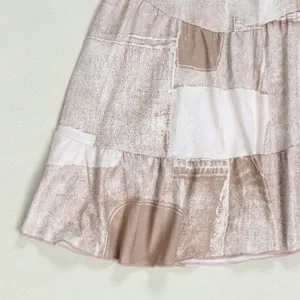 Detail view of tiered ruffled hem with neutral geometric abstract print pattern