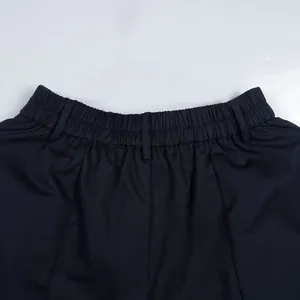 Detail shot of the elastic waistband and belt loops on navy blue commuter trousers