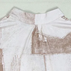Macro detail shot showing a minimalist stand collar with abstract brown floral prints
