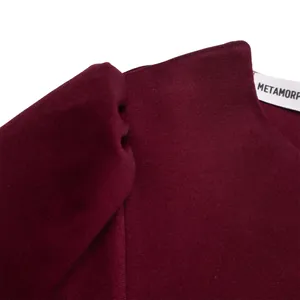 Detail view of burgundy ribbed knit texture and brand label on a stylish women's dress