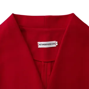 Dettaglio di un abito rosso alla moda con ampio colletto a revers ed etichetta del marchio