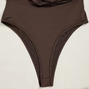 Close-up detail of a dark brown high-leg bodysuit showing premium stitching and fabric texture