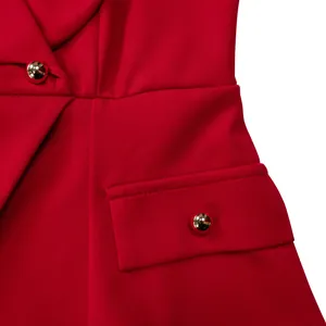 Vista dettagliata di un elegante vestito rosso con bottoni dorati e trama del tessuto.