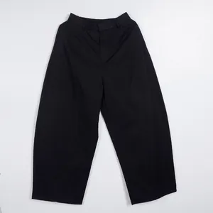 Front view of black loose silhouette commuting trousers featuring elastic waist detail