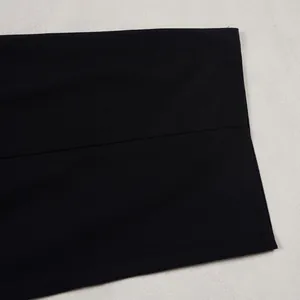 Close-up detail of high-quality smooth black fabric texture and stitching on casual trousers.
