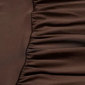 Close-up macro detail showing the dark brown pleated fabric texture and fine stitching