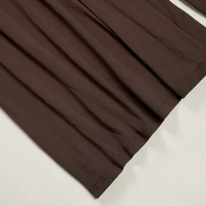 Detail of coffee brown pleated fabric showing smooth texture and fine stitching